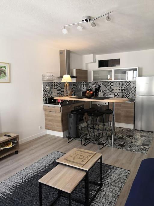 un salon avec une cuisine et une table dans l'établissement Les Arcades, T2 en hypercentre, à La Rochelle