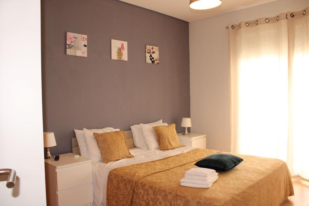- une chambre avec un lit doté d'oreillers blancs et jaunes dans l'établissement Appartement Pinheiro, à Portimão