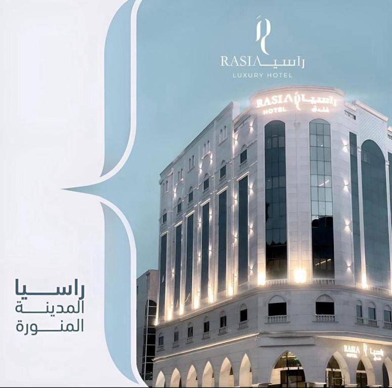 un edificio bianco con un cartello sul lato di فندق راسيا المدينة المنورة a Medina