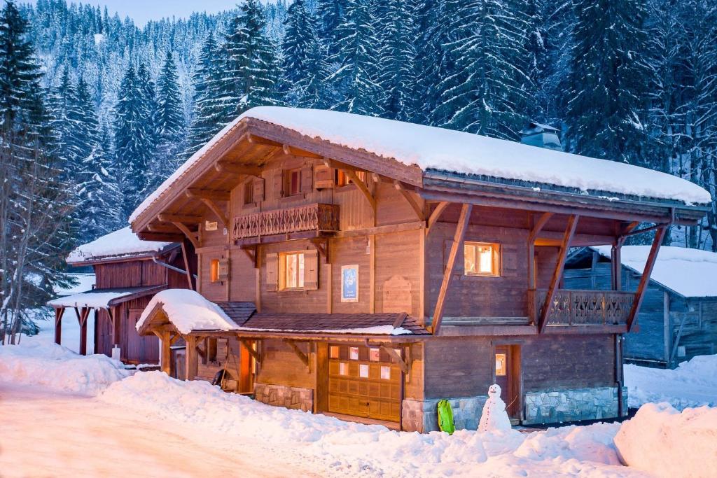una cabaña de madera en la nieve con nieve en Chalet Les Grolets - Ardent en Montriond