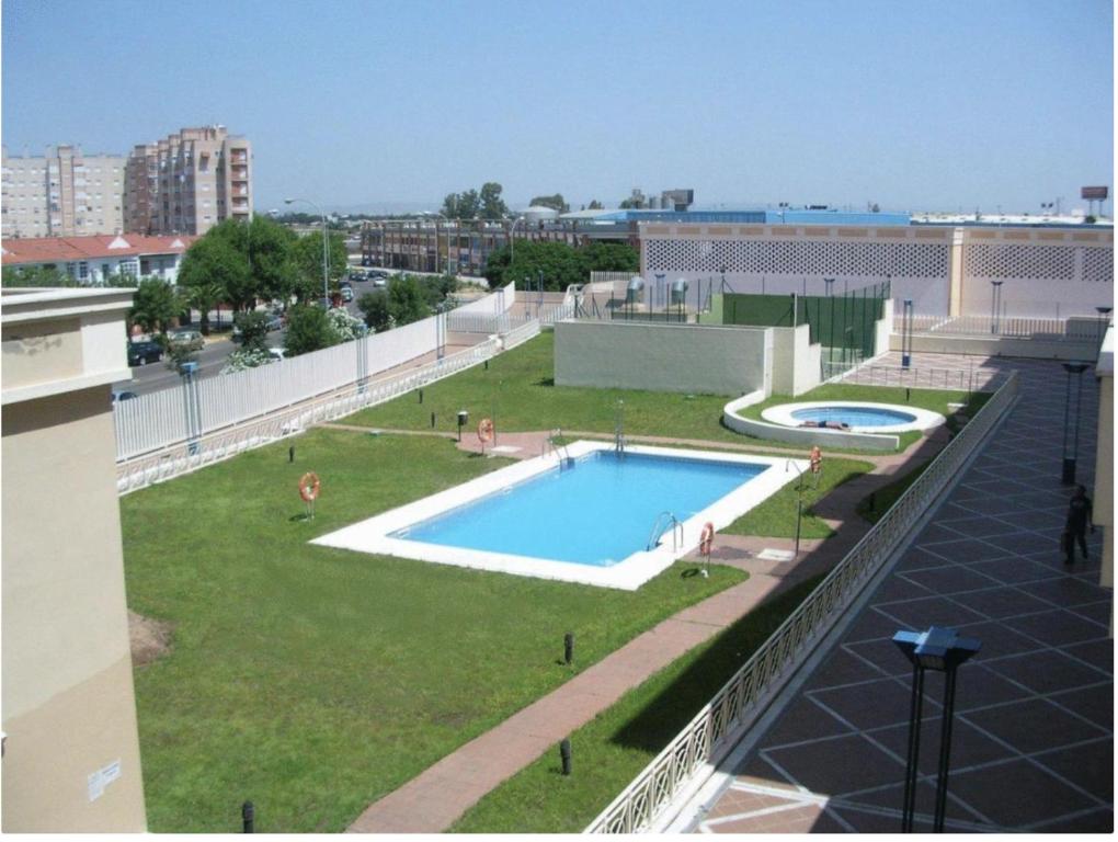 una grande piscina sul tetto di un edificio di SevillaHome-Apartamento complejo piscina parking a Siviglia