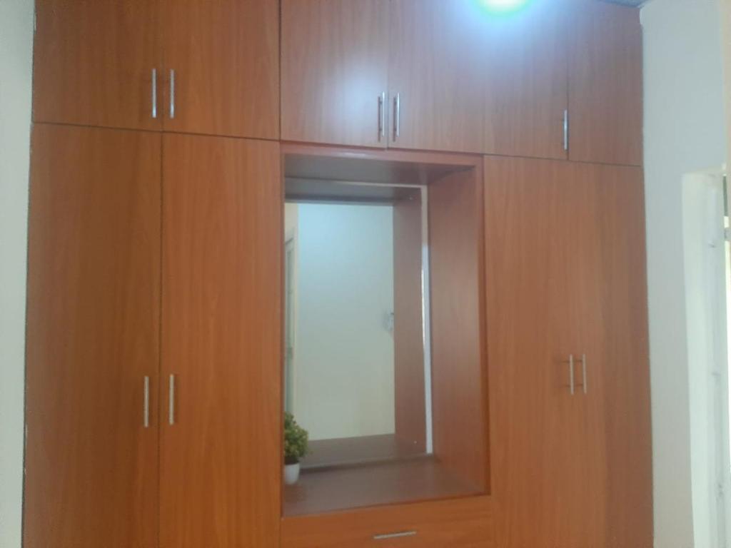 a wooden cabinet with a mirror in a room at Powerground Resort in Nairobi