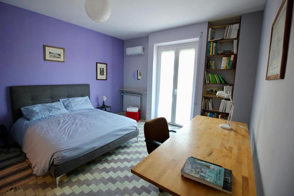 ローマにあるCASA UMBERTOの紫の壁のベッドルーム(ベッド1台、テーブル付)