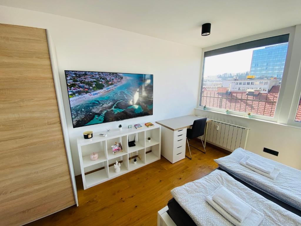 sypialnia z dużym oknem, łóżkiem i biurkiem w obiekcie Rok's Mini Penthouse w Lublanie