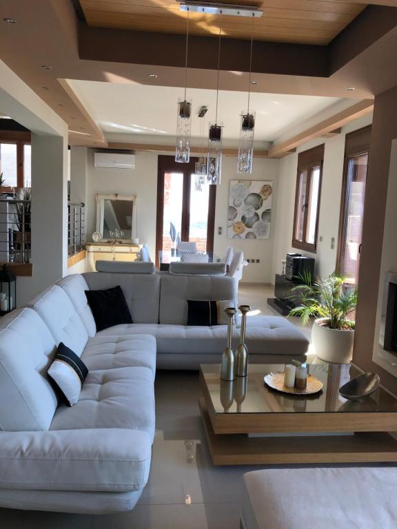 sala de estar con sofá blanco y mesa en Villa Under Meteora, en Kalambaka