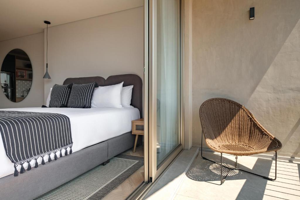 a bedroom with a bed and a chair on a balcony at Casa Cibeles by Lumina in Mexico City