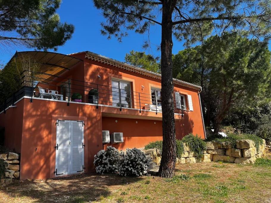 ein orangefarbenes Haus mit einem Balkon und einem Baum in der Unterkunft La villa Rosa in Bédoin