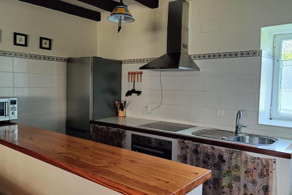 a kitchen with a wooden counter top and a sink at Casona Pico Candiano in San Miguel de Aras