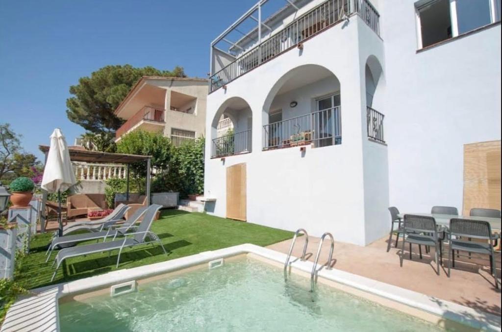a villa with a swimming pool and a patio at SeaHomes Vacations, LA CASA BLUE Mediterranean Lifestyle in Blanes