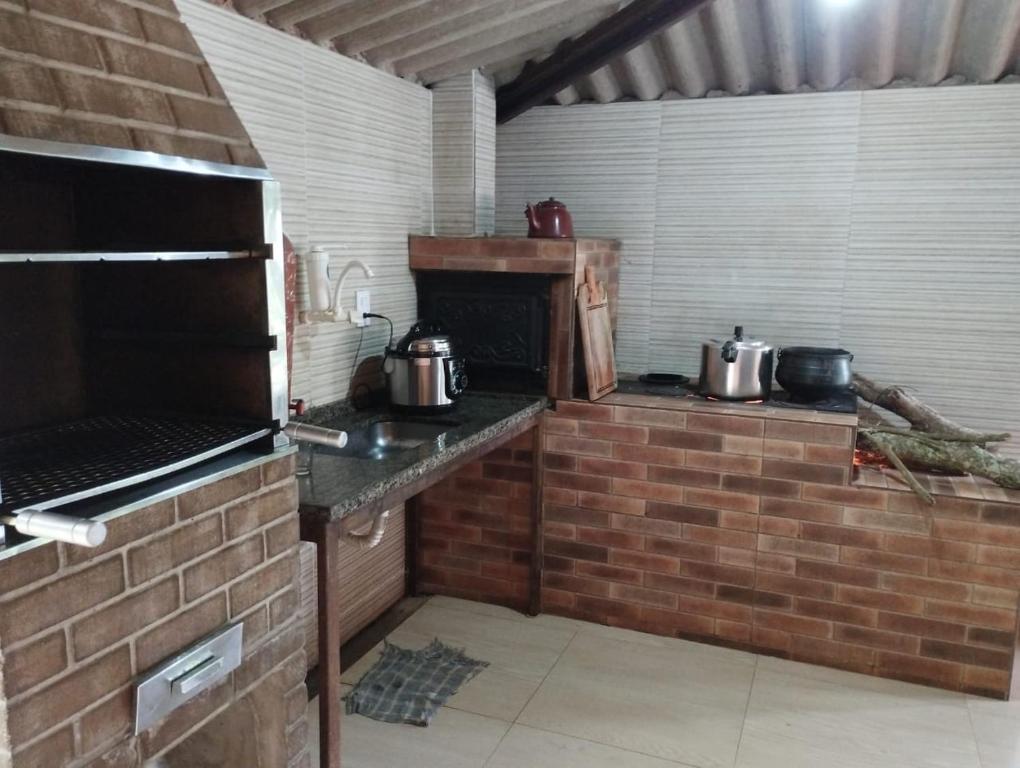 a kitchen with pots and pans on a brick wall at Casa da Vó Bia in Alto Caparao
