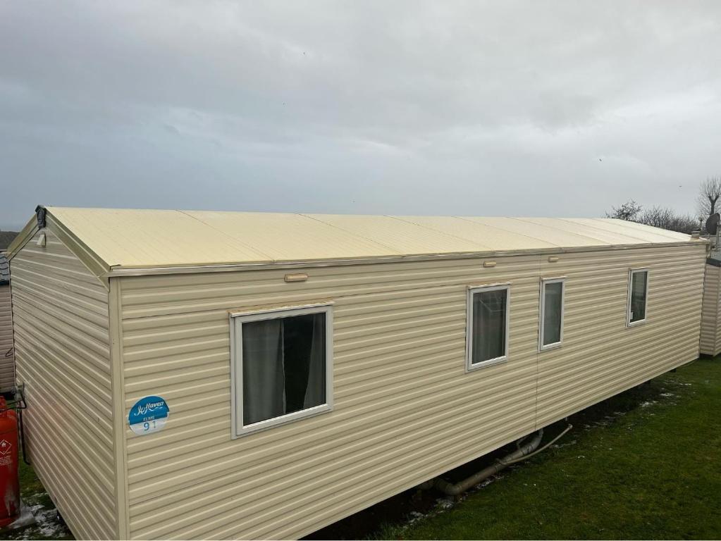 a large tan building with windows in a yard at Devon Cliffs Holiday Park - Haven, 3 Bed - ABI Horizon - Wi Fi in Exmouth