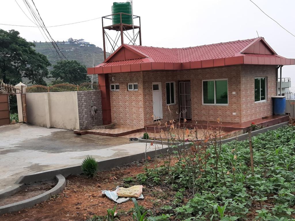 una pequeña casa de ladrillo con una torre de agua en la parte superior en Small house in boshan kathmandu, en Dakshīnkāli