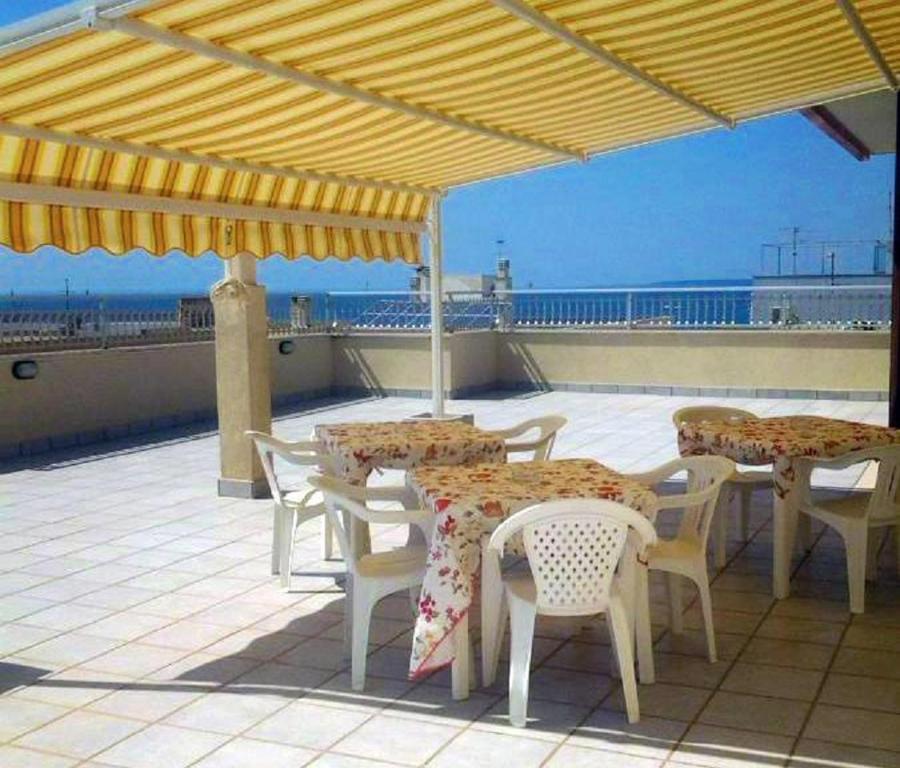 ガリポリにあるle terrazze sul mare gallipoliのパティオ(テーブル、黄色の傘下の椅子付)