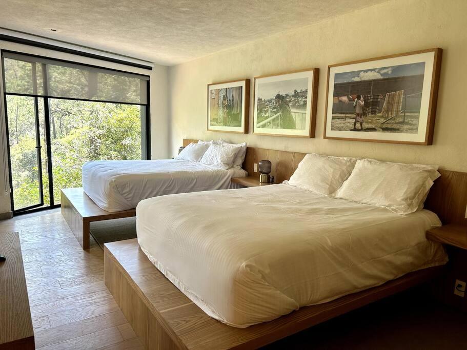 une chambre d'hôtel avec deux lits et une fenêtre dans l'établissement Suite boutique Oyamel en Avándaro, Valle de Bravo, à Valle de Bravo