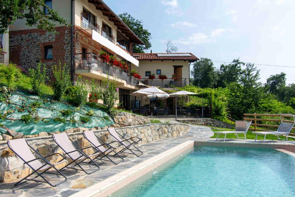 um resort com piscina e cadeiras e um edifício em Ca Montiglio em Quagliuzzo