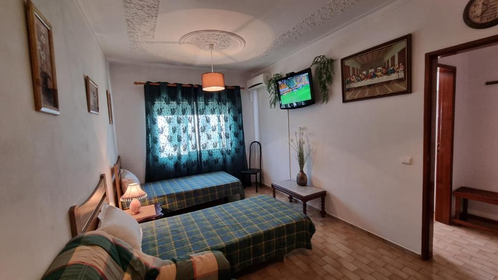 uma sala de estar com duas camas e uma televisão em Santa Isabel em Portimão