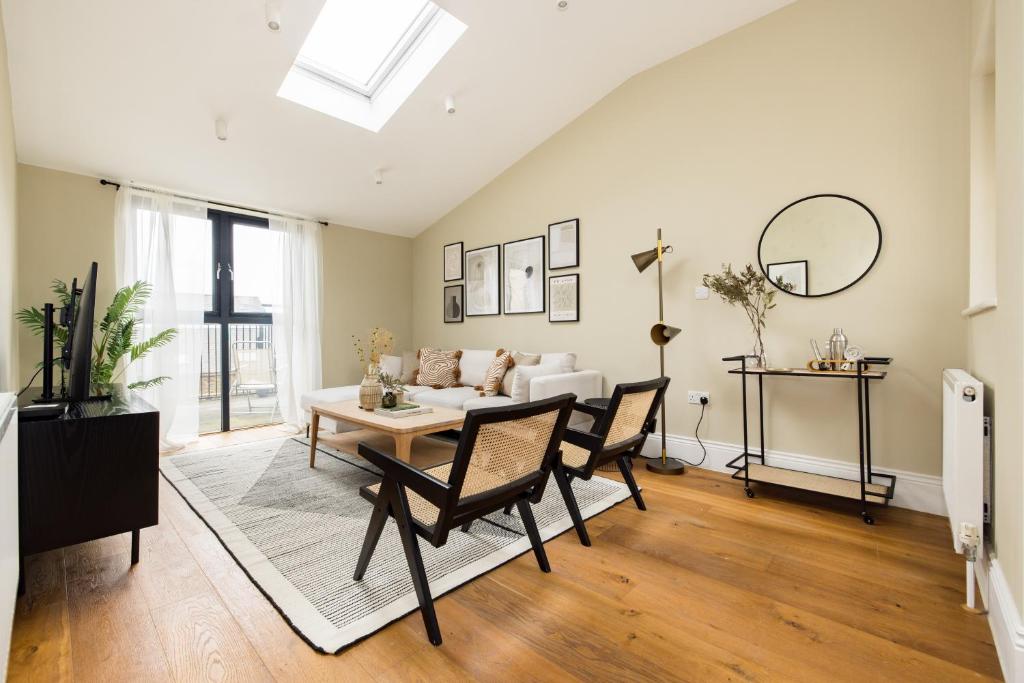 a living room with a table and chairs at The Tooting Hideout - Dazzling 3BDR Flat with Balcony in London