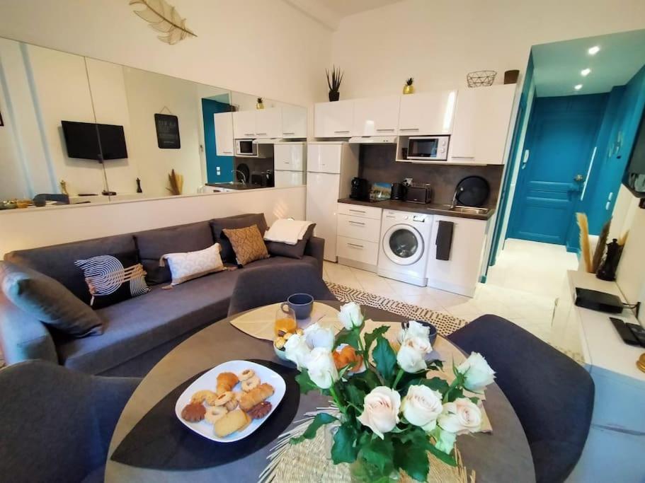 ein Wohnzimmer mit einem Sofa und einem Tisch mit Blumen in der Unterkunft Naomi cannes in Cannes