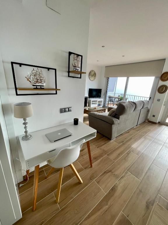 a living room with a desk and a couch at SeaHomes Vacations, LA CASA BLUE Mediterranean Lifestyle in Blanes