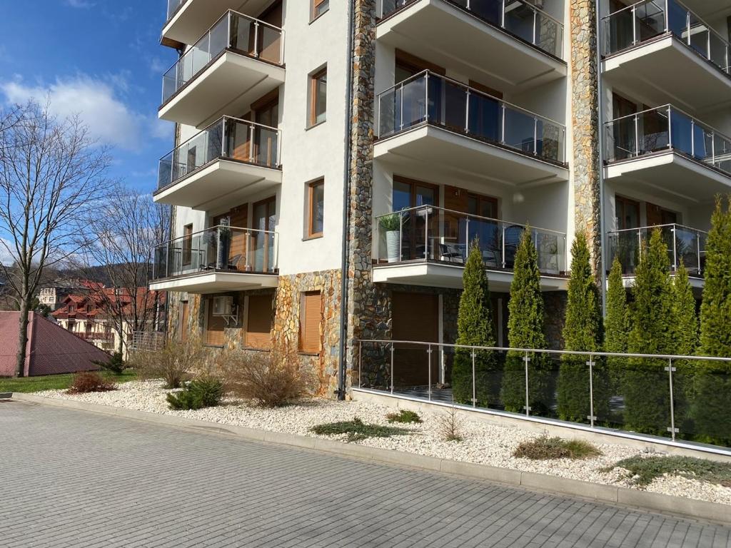 ein Apartmenthaus mit Balkon auf einer Straße in der Unterkunft Apartament CARPANO, Ogrodnicza 7 / KARPACZ in Karpacz