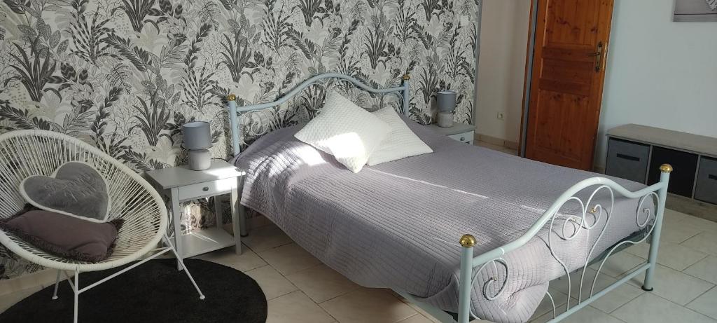 ein Schlafzimmer mit einem Bett und einem Stuhl in der Unterkunft Les garrigues in Pernes-les-Fontaines