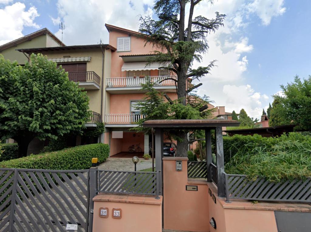 a house with a tree in front of it at Appartamento Chiesina Uzzanese - Toscana in Chiesina Uzzanese