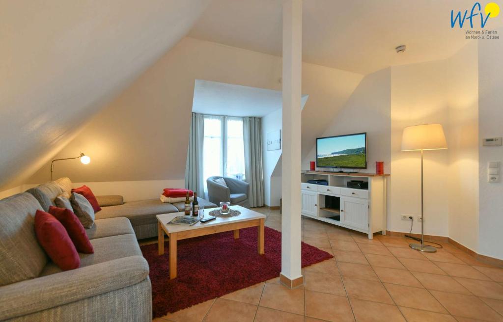 ein Wohnzimmer mit einem Sofa und einem TV in der Unterkunft Villa Vogelsang Ferienwohnung 12 in Binz