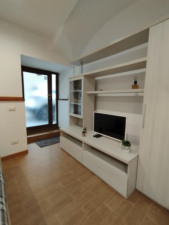 sala de estar con TV de pantalla plana y ventana grande en La casetta di Patry, en Tarquinia