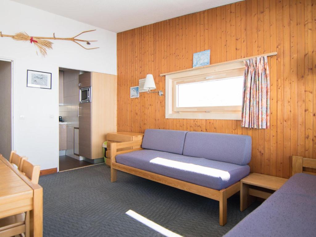 un salon avec un canapé bleu et une fenêtre dans l'établissement 2 pièces sud/ouest proche pistes, WiFi, animaux admis - FR-1-449-118, à Tignes