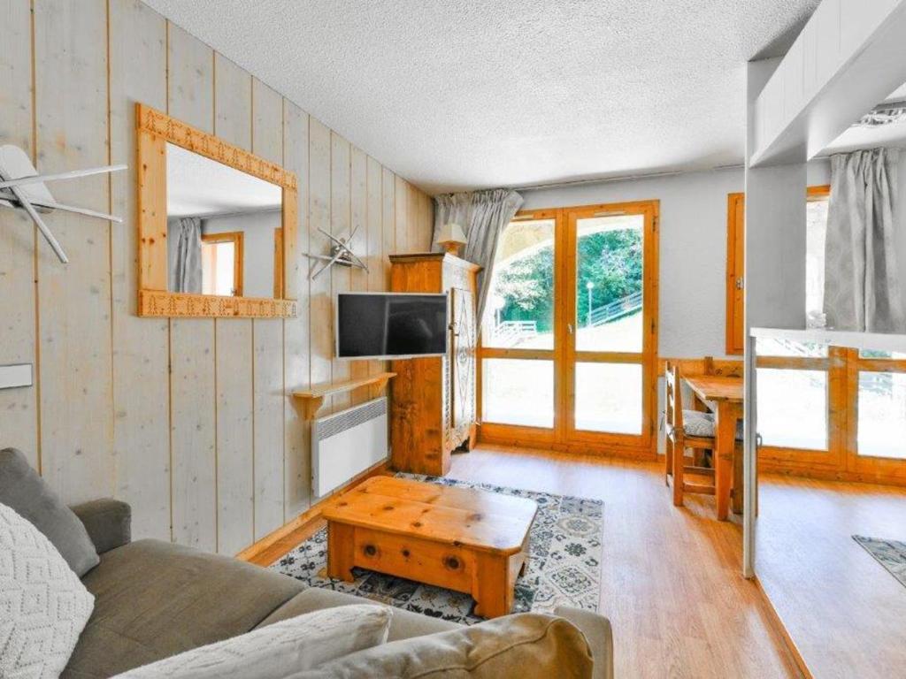 a living room with a couch and a table at Appartement rénové près des pistes avec terrasse, ski, parking et cuisine équipée - FR-1-514-48 in Courchevel