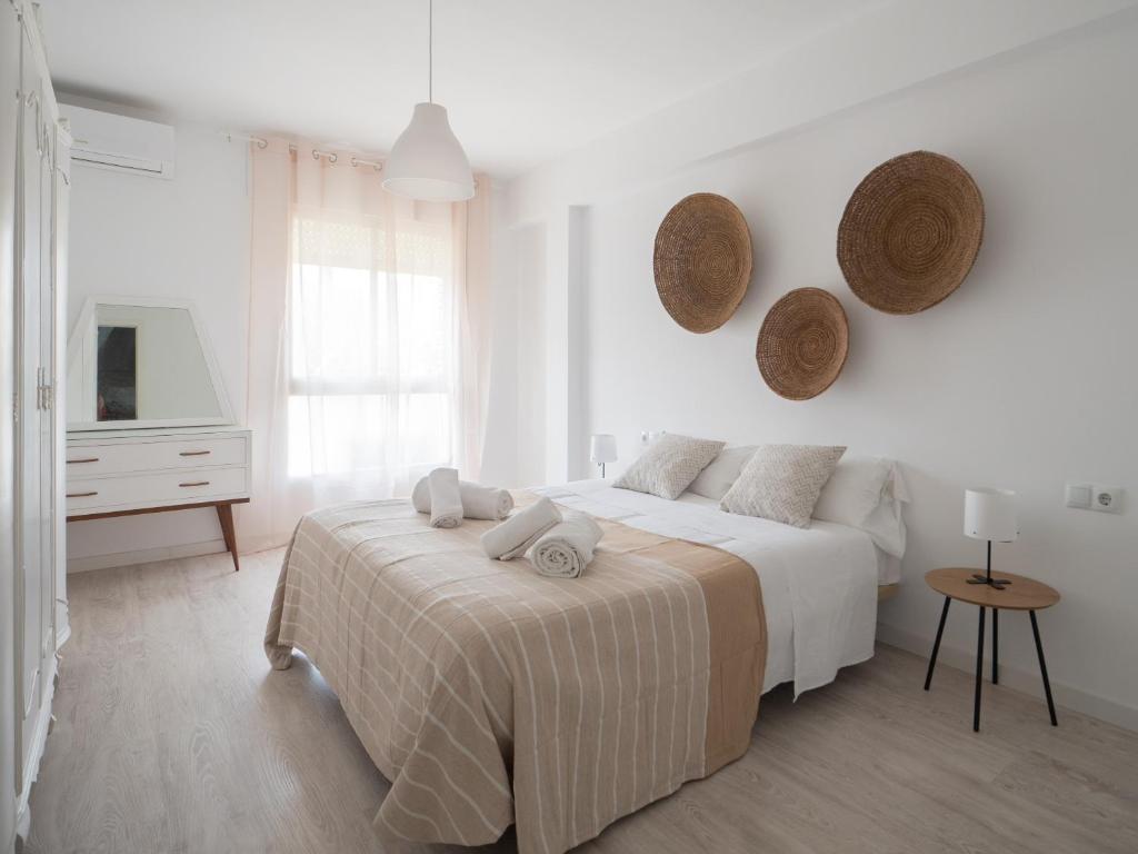 a white bedroom with a bed and a tv at Luxury Home Mezquita in Córdoba