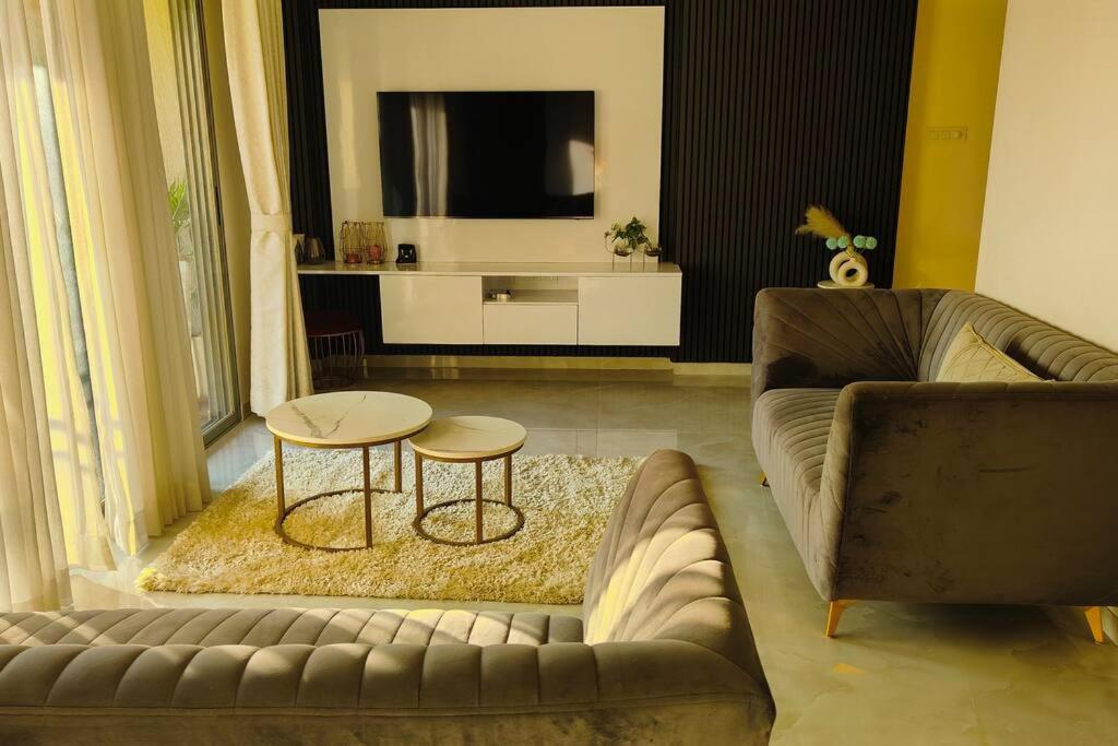 a living room with a couch and a tv at The Ten - Cozy 2bhk in Baner in Pune