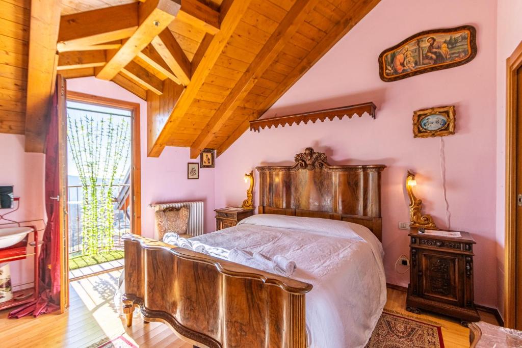 um quarto com uma cama de madeira num quarto em [Colazza] Luxury Suite Orchidea - La Casa dei Sogni em Colazza