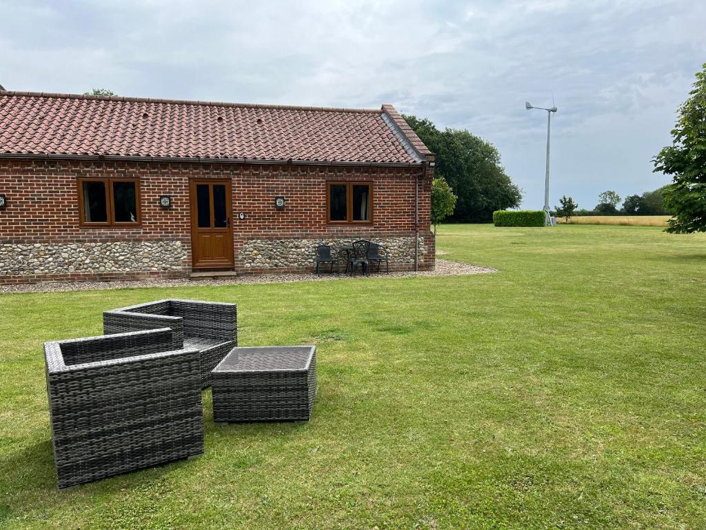 a brick house with two benches in a yard at The Annexe in Beeston