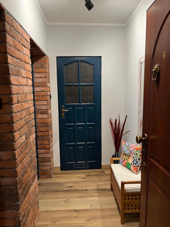 a blue door in a room with a couch at Apartament Piwna52 in Gdańsk