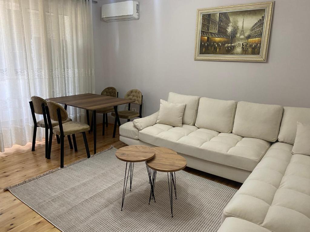 sala de estar con sofá blanco y mesa en Aimari’s Apartment, en Shkodër