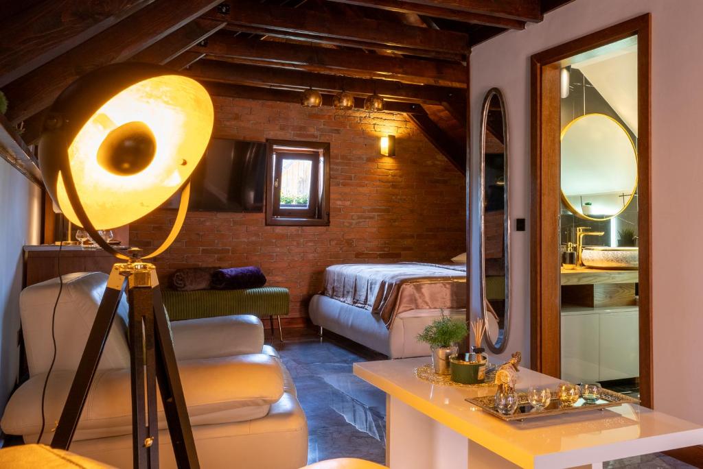 Habitación con cama y mesa con lámpara. en Studio apartman & Wine House ONDINE, en Zmajevac