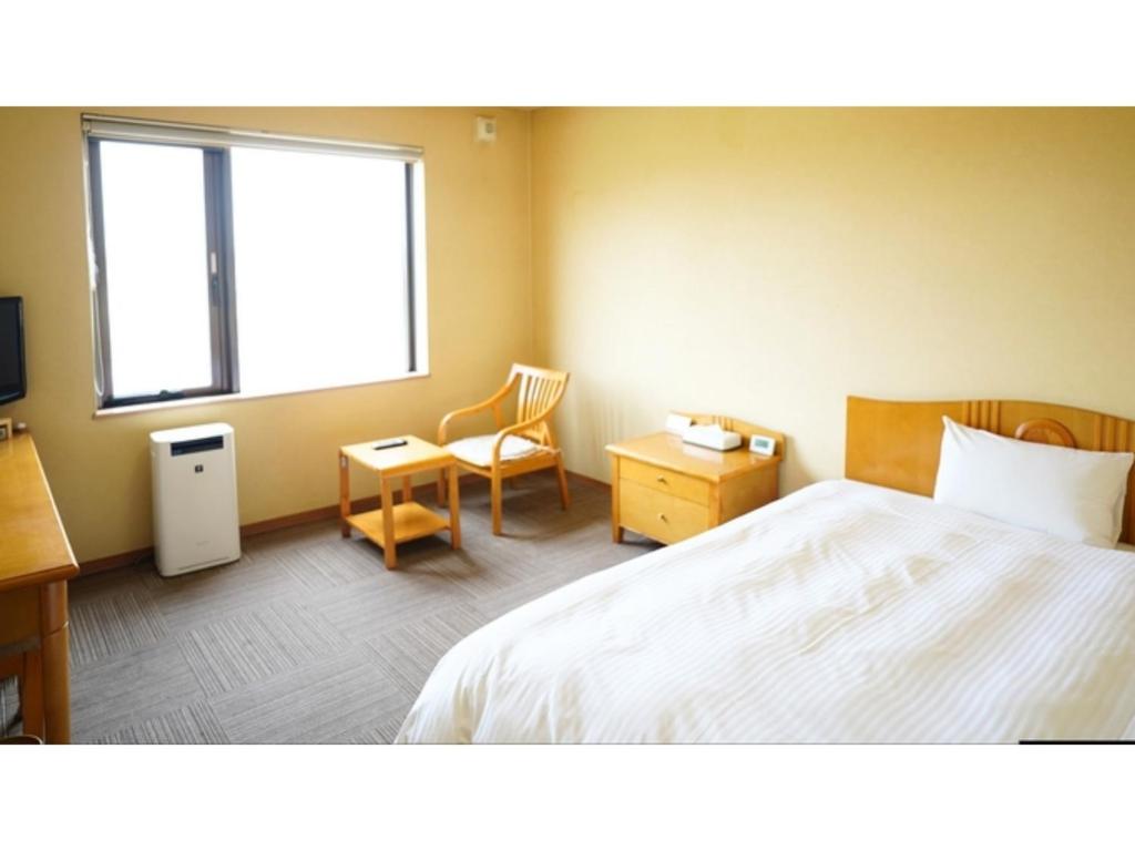 a bedroom with a bed and a desk and a window at Hotel Hounomai Otofuke - Vacation STAY 29499v in Otofuke