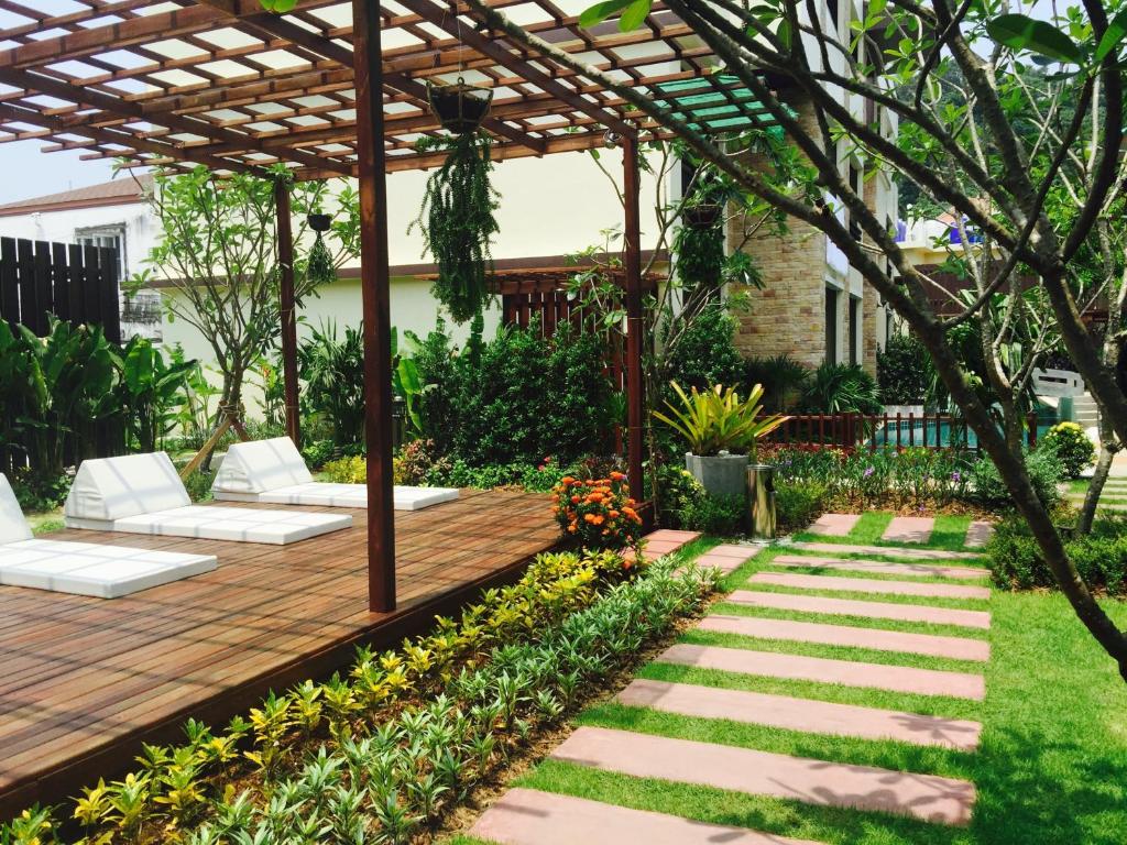 einen Garten mit einer Holzterrasse und einer Pergola in der Unterkunft JJ Residence in Ko Phi Phi