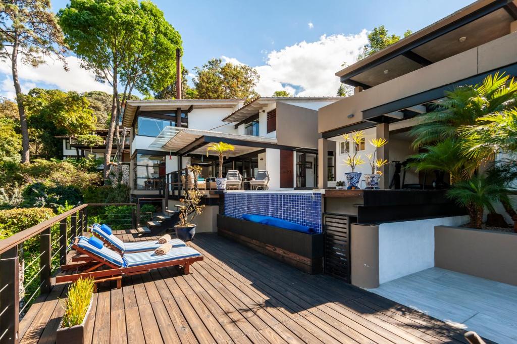 a house with a deck with a swimming pool at Hermosa Casa con Terraza y Vista al Lago en Avándaro in Valle de Bravo