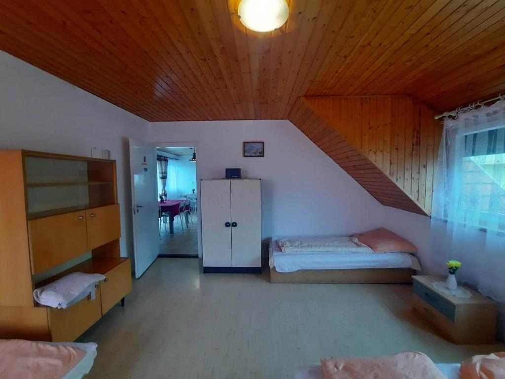 a bedroom with two beds and a wooden ceiling at Badacsonyi családi privát házak in Badacsonytomaj