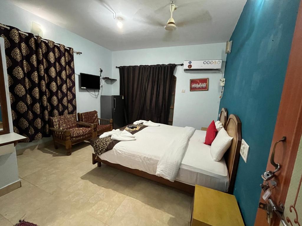 sypialnia z łóżkiem i krzesłem w pokoju w obiekcie Hotel Ocean Face, BAGA w mieście Baga