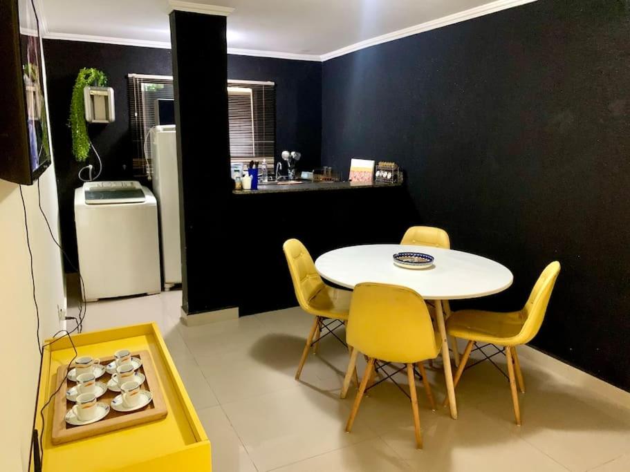 a kitchen with a table and chairs and a refrigerator at 2 Quartos Completo Barato in Brasilia