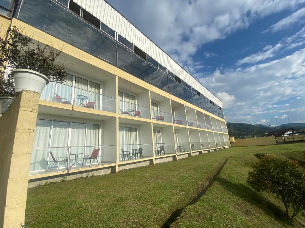 a building with chairs on the side of it at Hotel Entre Lomas in Santa Rosa de Cabal