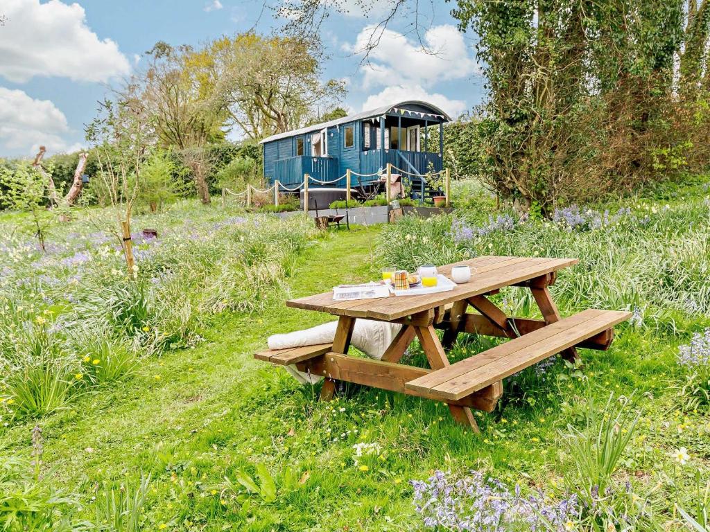 een picknicktafel en een blauwe trailer in een veld bij 1 Bed in Bodmin Moor 91964 in South Petherwin