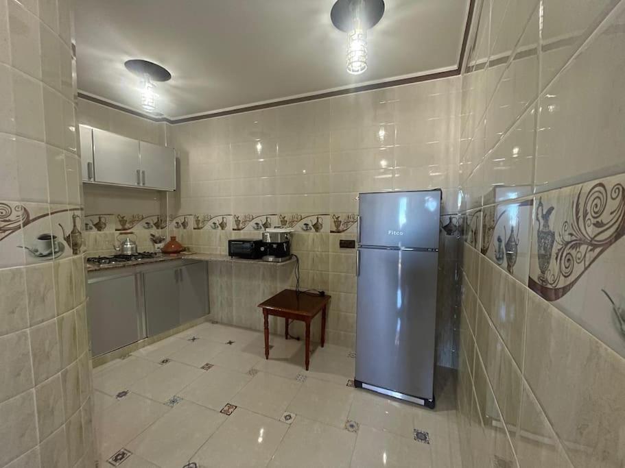 eine Küche mit einem Kühlschrank und einem Tisch darin in der Unterkunft apartment with terace in Chefchaouen