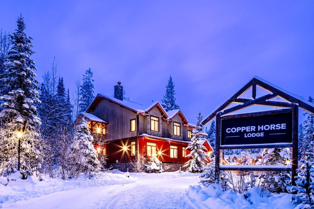 eine Hütte im Schnee mit einem Schild davor in der Unterkunft Copper Horse Lodge in Golden