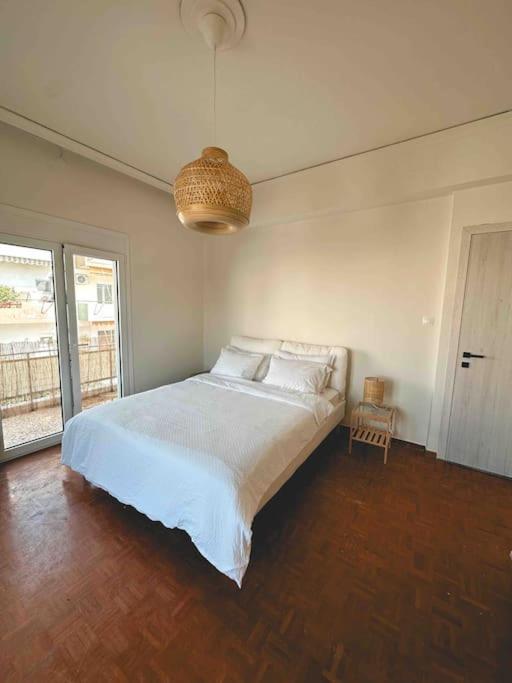 una camera da letto con un letto grande con lenzuola bianche di Linear Flat - City Center - Private Parking a Chania