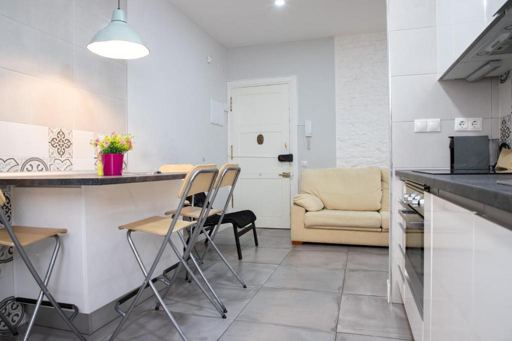 cocina con encimera y sillas en una habitación en Apartamento de 4 dormitorios en Retiro, en Madrid