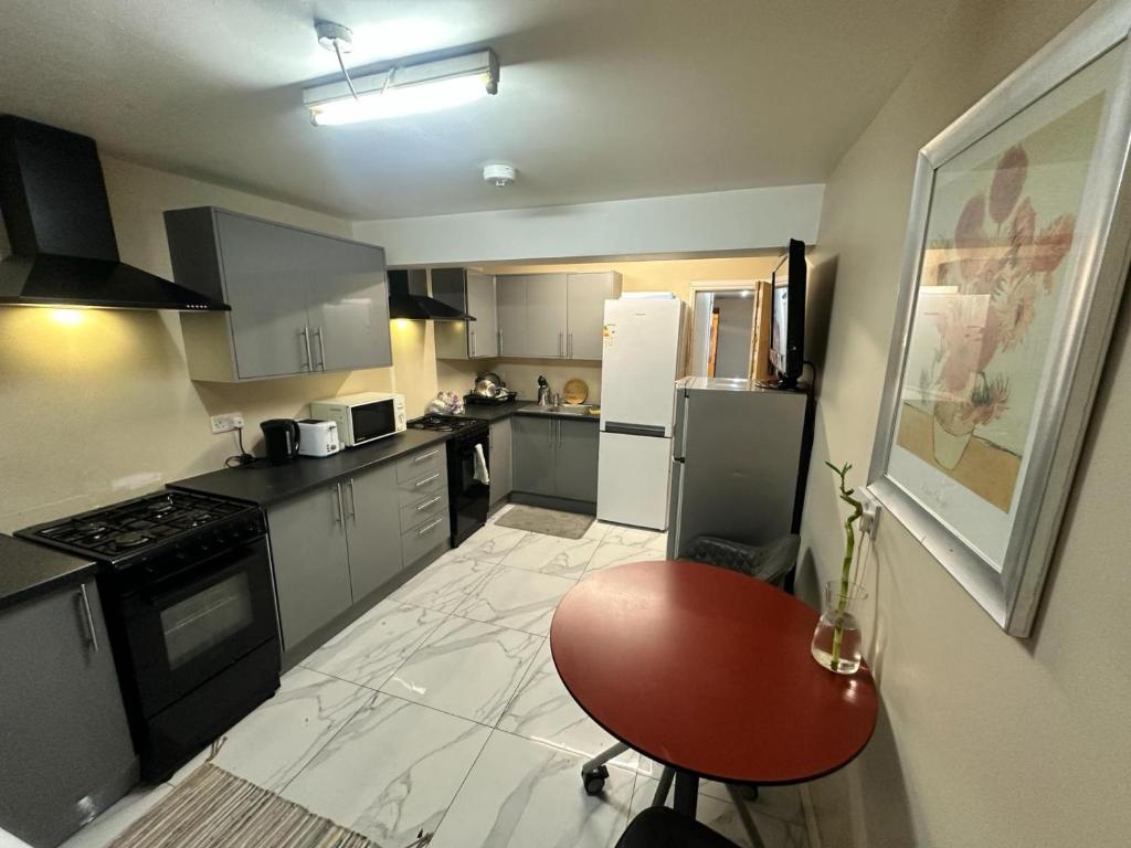 a kitchen with a red chair and a refrigerator at Bethnal Green Rooms R4 in London